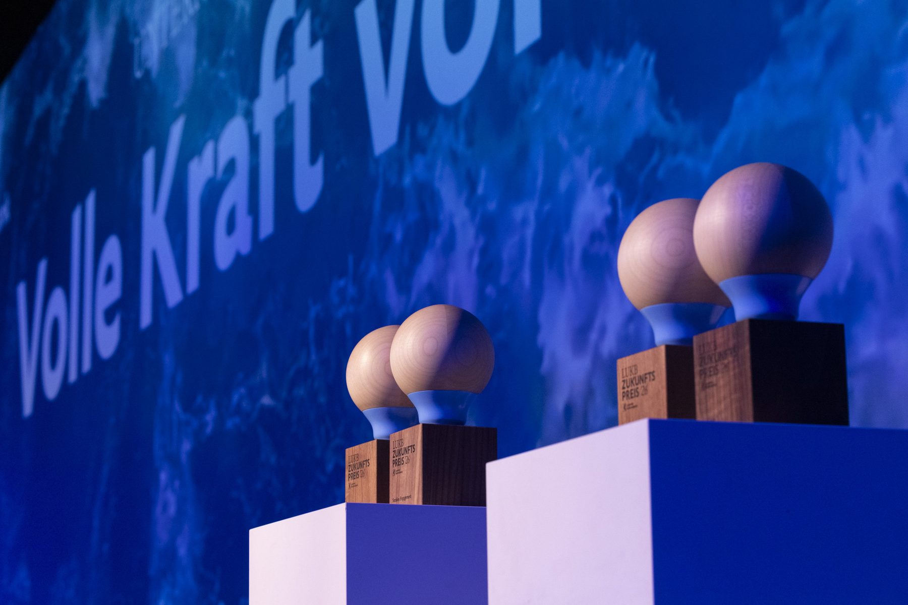 Trophäen des LUKB-Zukunftspreises 2026 auf der Bühne